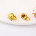 Pair of matte gold charms with bell shapes and delicate bow details on a ceramic dish - 21# Sand Gold Pinecone Bead Cap