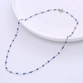 Silver titanium steel necklace with blue enamel lip-shaped charms on a white plate - Steel + Blue Enamel