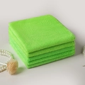 Set di 4 panni in microfibra verde impilati su una superficie bianca minimalista - Verde