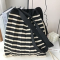 Dettaglio della borsa in maglia a righe bianche e nere con pieghe e ampia tracolla nera - Righe Nere e Beige