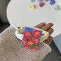 Close-up of a French style hair scrunchie with embroidered floral patch detail - Vibrant Pink Chrysanthemum