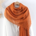 Solid orange crinkled cotton linen scarf with frayed edges worn by a model - Orange