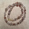 Macro shot of copper rutilated quartz chip stone necklace with golden lobster clasp detail - Copper Rutilated Quartz