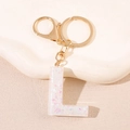 Détail du porte-clés lettre L en résine avec paillettes et fermoir doré chic - Lettre L