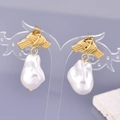 Elegant gold twisted metal earrings with baroque pearls on a gradient background - 18K Gold