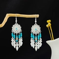 Bohemian silver earrings with sky blue beads and leaf tassels on a wooden branch - Blue