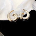 Makro-Detail von silbernen Spiralschnecken-Ohrringen mit hochglanzpoliertem Finish - Silber (Silberstift)