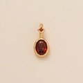 Gold pendant with oval red gemstone and star detail on light textured background - Oval January (Red Zirconia)