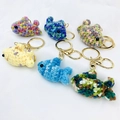 Detailed view of six colorful handmade crochet fish keychains with gold metal rings - Random Mixed Styles