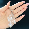 Detailed macro view of resin conch charms with sequins and pearls on a keychain - White