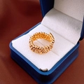 Macro detail of multi-layered gold beaded ring with faceted metal texture on velvet box - Gold