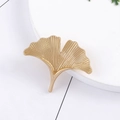 Elegant gold ginkgo leaf shaped metal brooch pin displayed on a white round base - Brushed Gold Style (C2070-2)