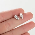 Detail shot of mini silver leaf studs on finger showing small size and brushed texture - Leaf / Silver