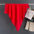 Detail of red cotton linen scarf draped on a metal hanger in a stylish studio setting - Red