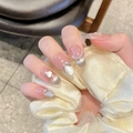 Detalle de uñas postizas hechas a mano ojo de gato con perlas y strass en la mano - Extra Pequeño (XS) / Ovalado Mediano (2142)