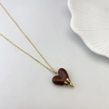 Elegant gold chain necklace with a dark brown heart pendant and golden fluid accent - Brown