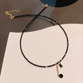 Collana con nappe in cristallo nero e chiusura dorata su sfondo materico raffinato - Stile Nappa in Cristallo Nero (WN801) / Nero
