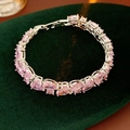 Detail of pink pear-cut and heart-shaped zircon bracelet on green velvet background - Pink