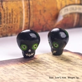 Macro view of 2x2.4cm resin skull bead with purple eyes and stitched mouth detail - Black Skull