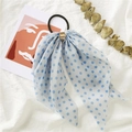 Detail of light blue polka dot bow hair tie with gold buckle on a white fabric surface - Polka Dot Blue