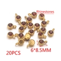 Set di 20 ciondoli portafortuna da 6x8,5 mm in acciaio dorato con strass rossi - Marrone
