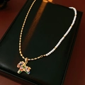 Close-up of vintage zircon pony necklace with gold chain and white pearl details - Gold White Necklace (Multicolor Pendant)