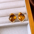 Detailed view of amber resin geometric earrings with golden frames on soft fabric - Silver Needle / Gold Brown Curved