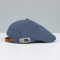 Detail of navy blue fabric cap with brown leather strap and vintage brand label - Haze Blue