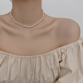 Elegant woven pearl necklace with zircon accents on a model in beige top - Gold