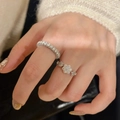 Macro shot of silver-tone flower-shaped and pavé band rings with sparkling zircons - Adjustable / Silver Snowflake Ring