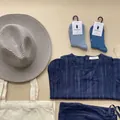 Flat lay of gray woven straw sun hat with navy striped outfit and canvas tote bag - Silver