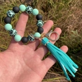 Bracelet porte-clés perles léopard et vert menthe avec pompon tenu à la main - Vert Menthe