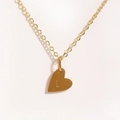 Gros plan du collier coeur doré avec la lettre L gravée sur une chaîne en or - Lettre L