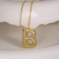 Zircon-studded letter B necklace in gold finish on a white minimalist display stand - Letter B (Box Chain)