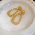 Macro view of yellow resin geometric oval earrings displayed on a white ceramic plate - Khaki (Silver Needle - Khaki Resin Oval Earrings)