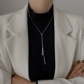 Collar largo minimalista con colgante de triángulo plateado sobre jersey de cuello alto - Plateado