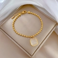 Close-up of a gold titanium steel beaded bracelet with a square cat-eye stone on velvet - Gold Square Cat Eye Stone Style (P117 Gold)