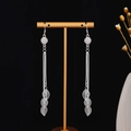 Detail view of silver tassel earrings with delicate chains and hollow leaf pendants - Bright Silver Ball Hollow Leaf Tassel Style (E5107-4)