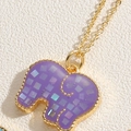 Macro shot of 14K gold plated elephant pendant with purple shell and colorful sequins - Purple