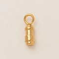 Macro detail of a 18K gold-plated cylindrical stainless steel pendant with top jump ring - Bullet Tip