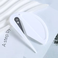 Minimalist white utility cutter tool placed on a magazine with sharp metal blade detail - White
