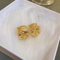Dettaglio orecchini dorati con texture irregolare su tessuto morbido bianco - Perno in Argento (26#) / Oro