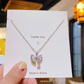 Collier à pendentif nœud en argent scintillant avec zircone sur carte d'affichage - Nœud Papillon en Zirconium Argenté