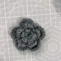 Detail of a 7cm grey triple-layered crochet flower showing yarn texture on a cutting mat - 7cm / Mohair Grey