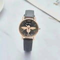 Detailed top view of a luxury watch with golden bee motif on dark grey dial and leather strap - Gray