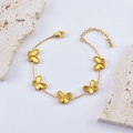 Golden double-sided embossed butterfly charm bracelet on stone display stand - Butterfly Bracelet