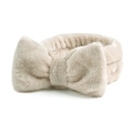 Detailopname van beige koraalvlies hoofdband met een zachte pluche decoratieve strik - Abrikoos