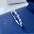 Macro shot of S925 silver eternity ring with blue and white round brilliant-cut stones - Aqua