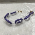 Detailed view of purple acrylic chain links with a gold round clasp on white faux fur - Frosted Blue Purple