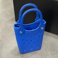 Close-up of blue EVA beach tote bag featuring circular laser-cut hollow holes and silver rivets - Blue